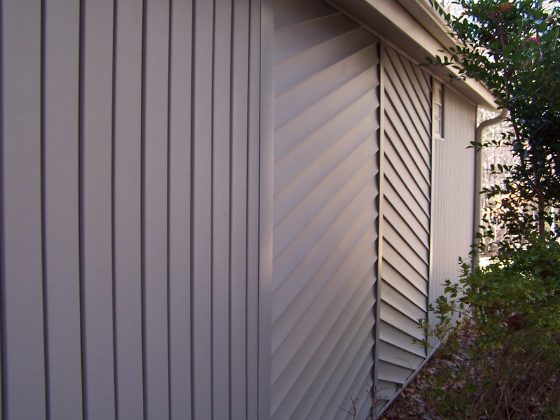 Vertical and diagonal vinyl siding on the side of a house.