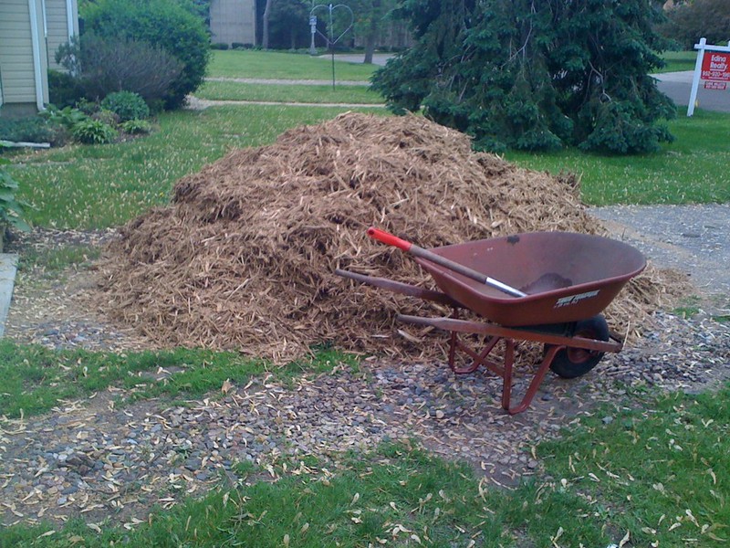 Pile of mulch next to a wheelbarrow
