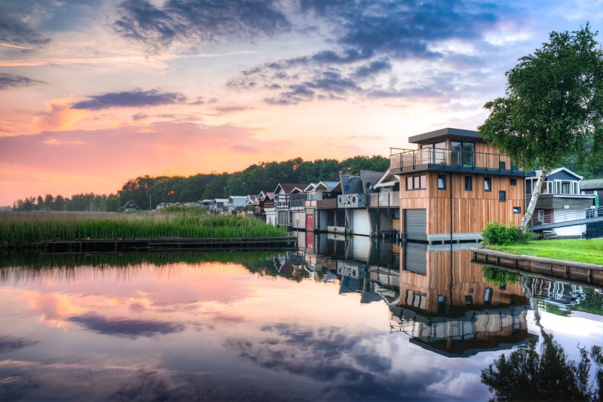 row of contemporary houses overlooking lake at sunset
