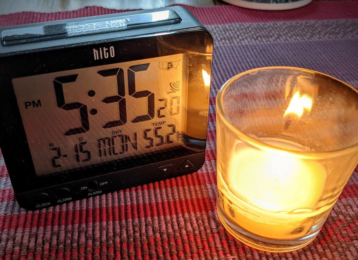 Battery-operated clock and candle in Irving, Texas, after power has gone out during major winter storm in February 2021