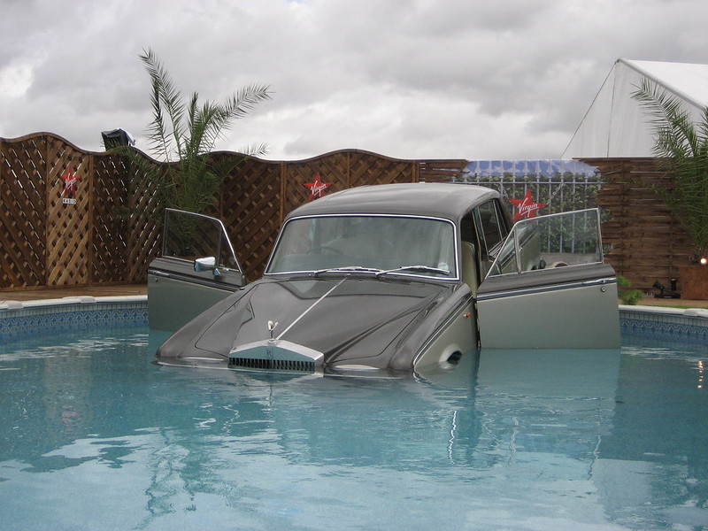 Rolls Royce halfway in a backyard pool