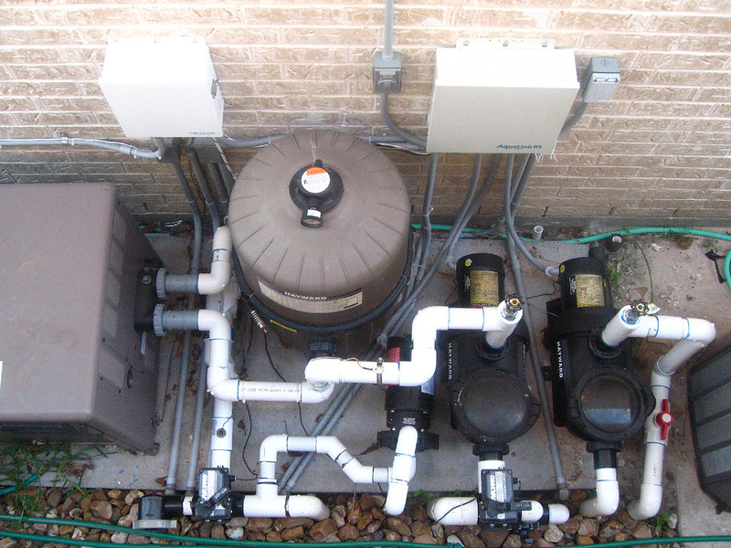 Looking down on pool equipment, including pool pump and pvc pipes