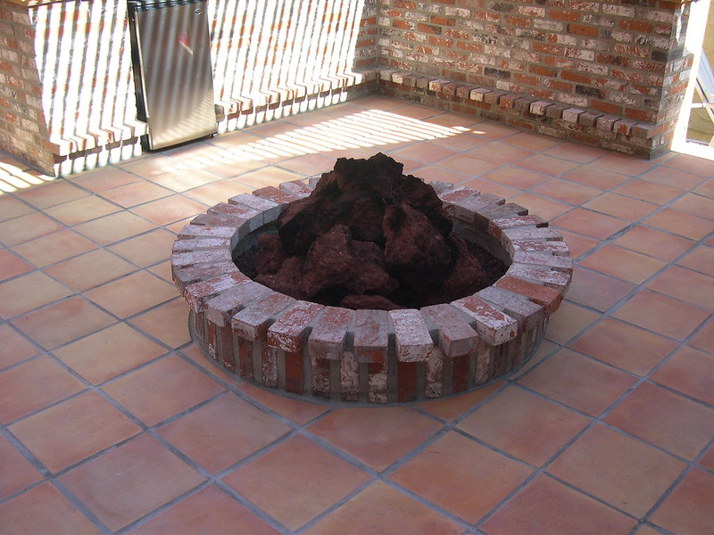 Backyard brick fire pit set in a tile patio