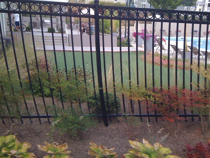 Aluminum pool fence with some landscaping along it