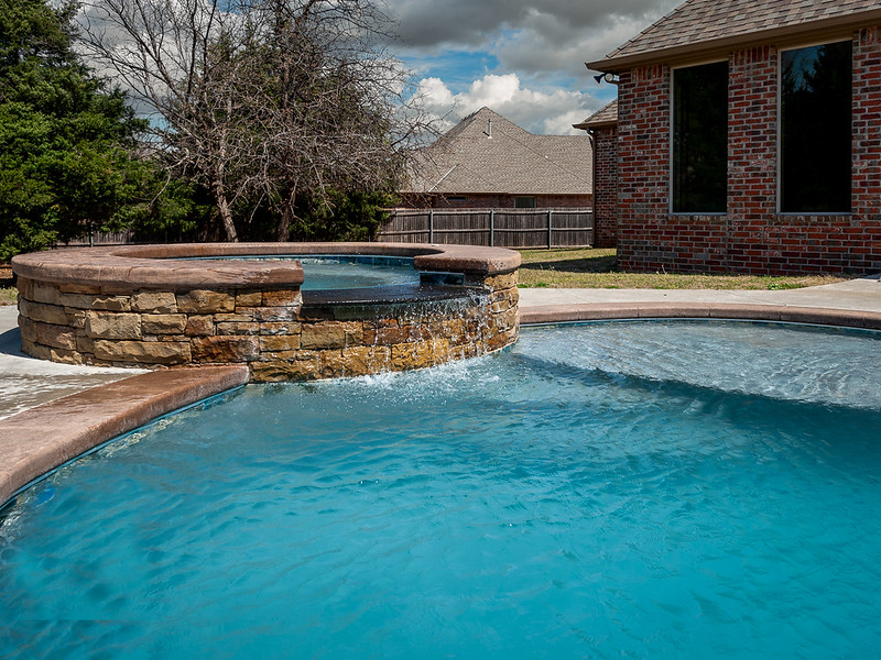 Stone hot tub attached to an in-ground pool