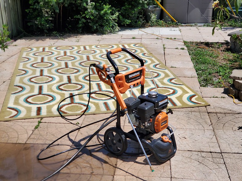 Pressure washer sitting outside next to a rug