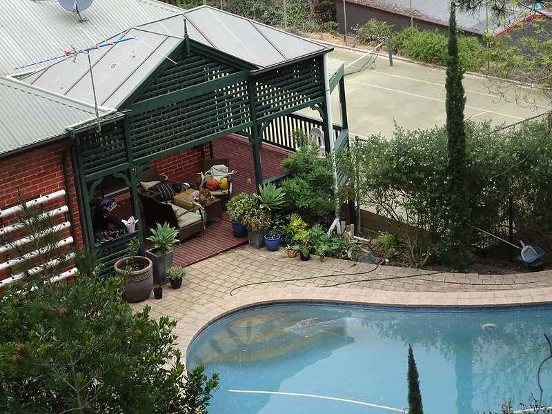 In-ground pool with a covered patio next to it