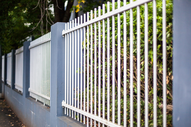 White metal fence between concrete pillars