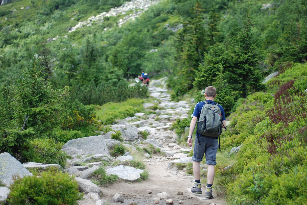 man hiking with backpack on mountain trail