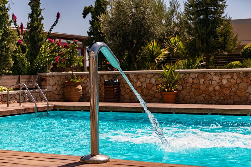 Water jet spraying water into a pool from above