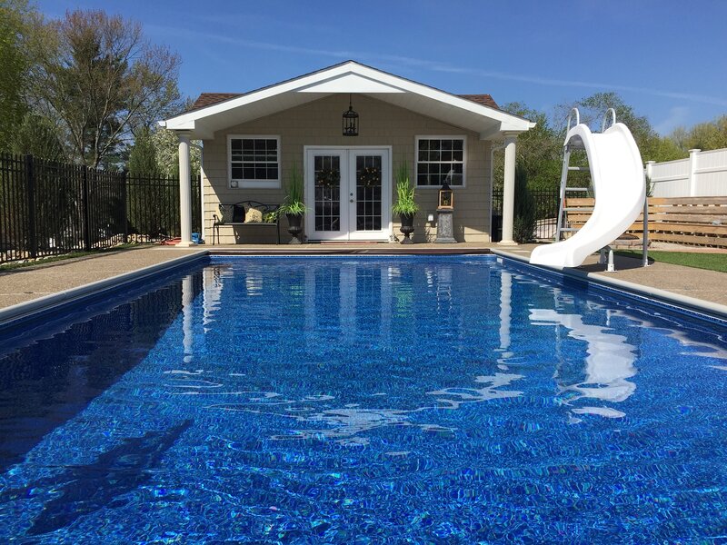 Pool in the foreground with a pool house in the background