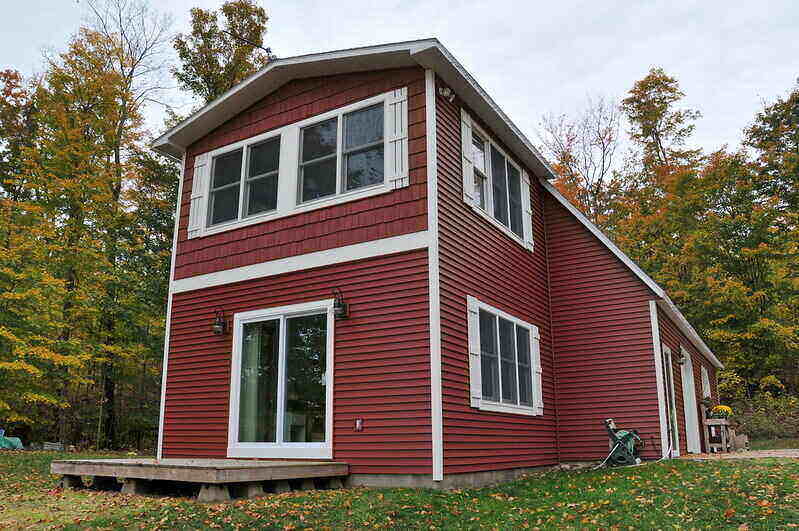 Front of a house with shake vinyl siding on the upper half of the house