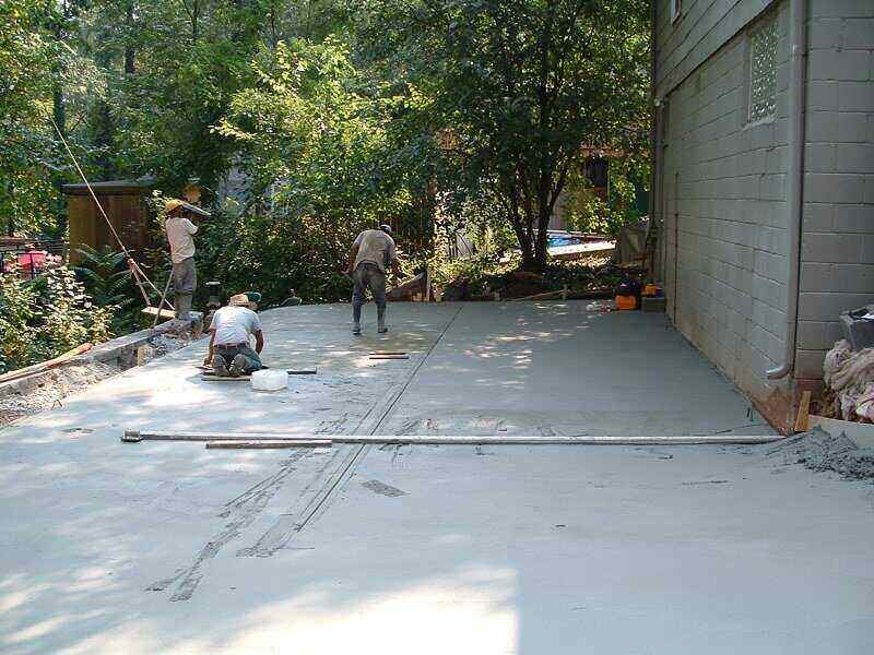 Workers leveling concrete for a driveway