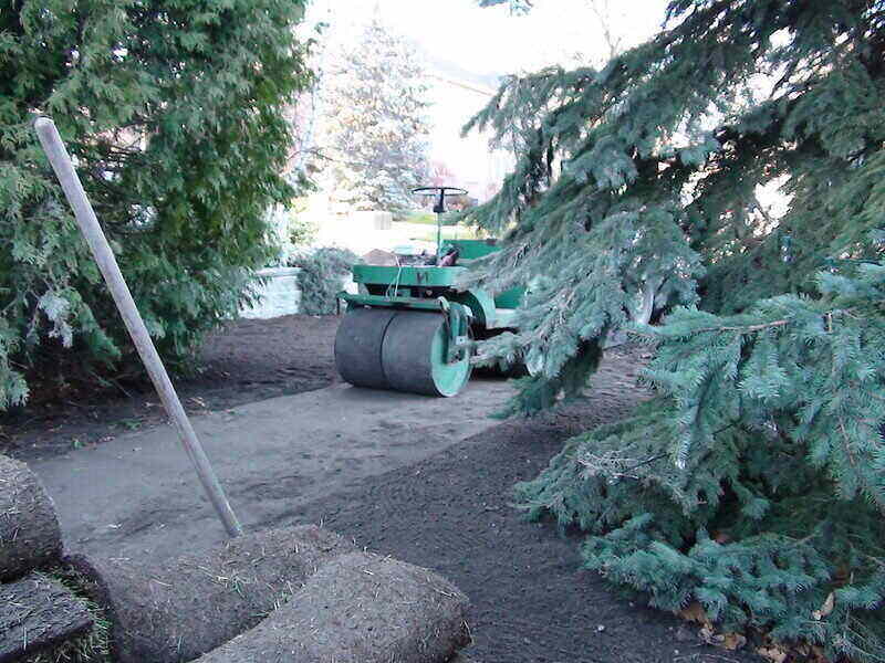 Smooth drum roller leveling out an area of land for sod installation