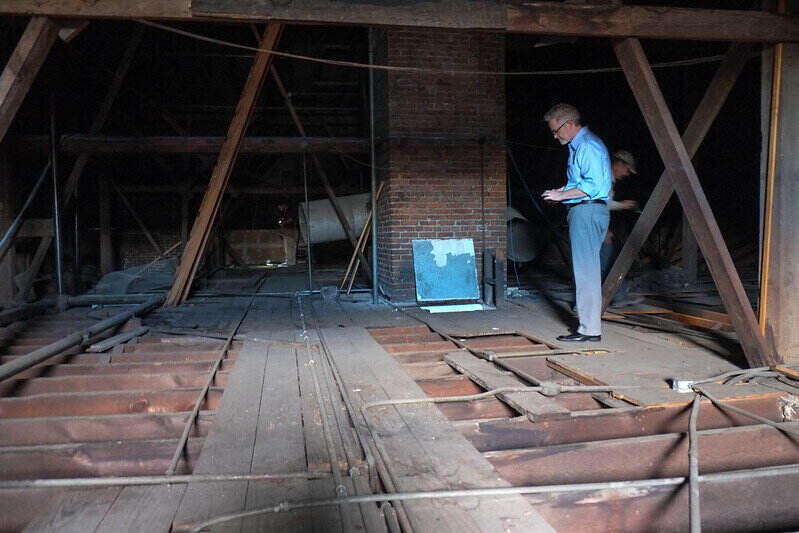 Home inspector standing in an attic, near a brick chimney