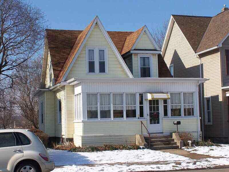 Picture of the front of a house that has light yellow siding