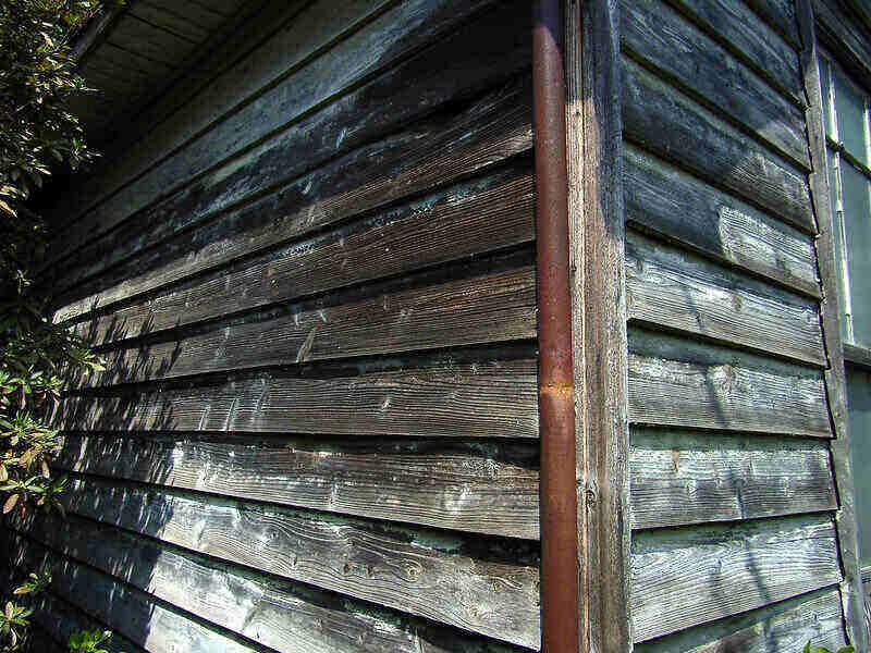 Close-up of the corner of a wood sided building.