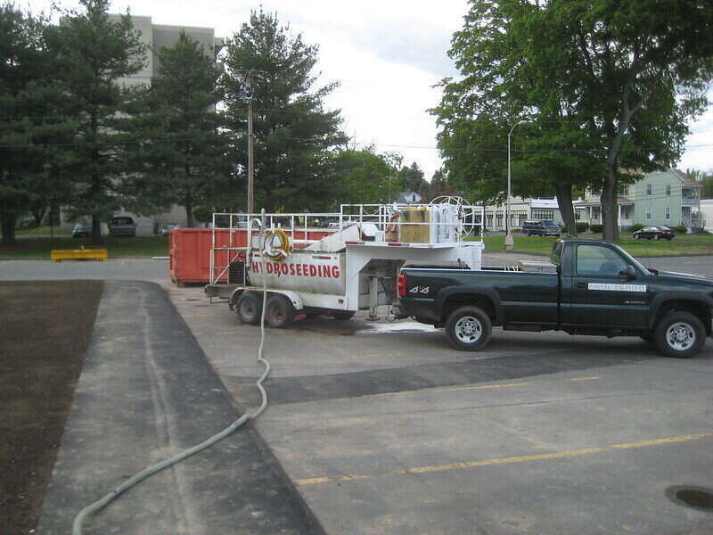 Pickup truck pulling a hydroseeding tanker behind it