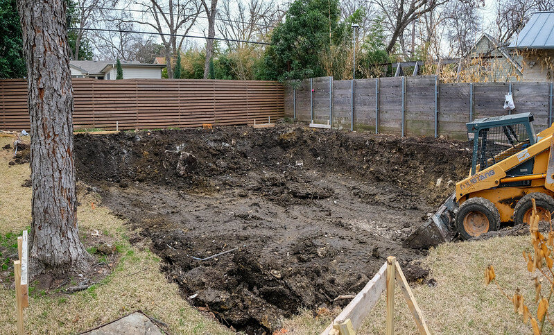 Skid steer digging out a large hole