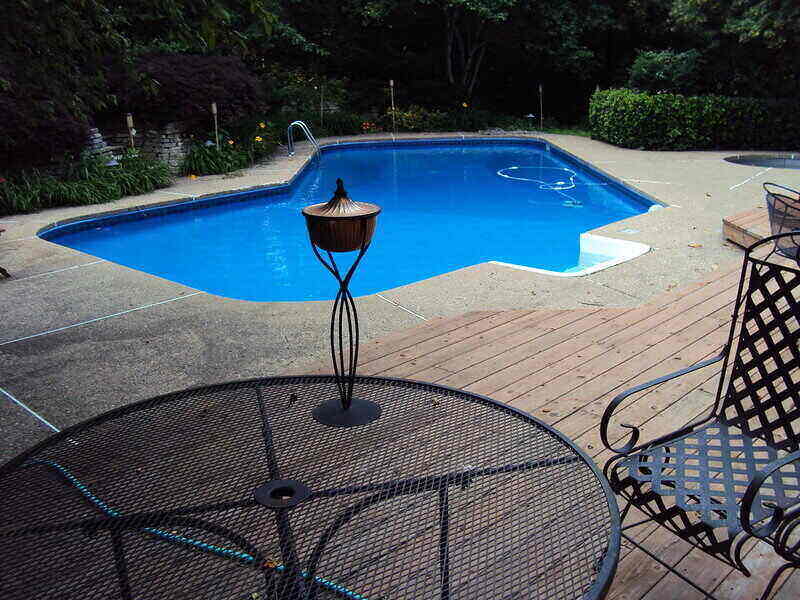 Backyard, in-ground pool with a patio set in the foreground