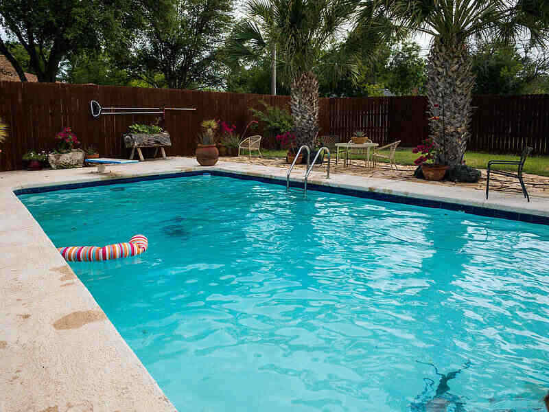 IN-ground pool with a diving board and landscaping