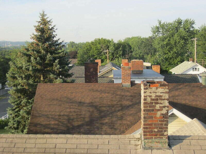 Picture of a series of house rooftops and they all have chimneys