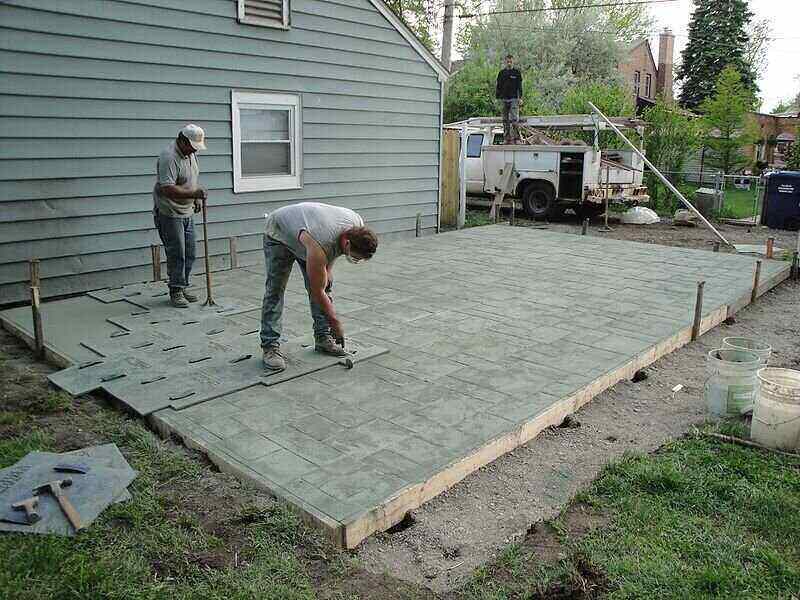 Workers stamping concrete for a patio