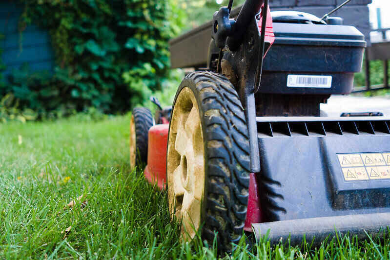 Close-up of the back of a lawn mower cutting grass