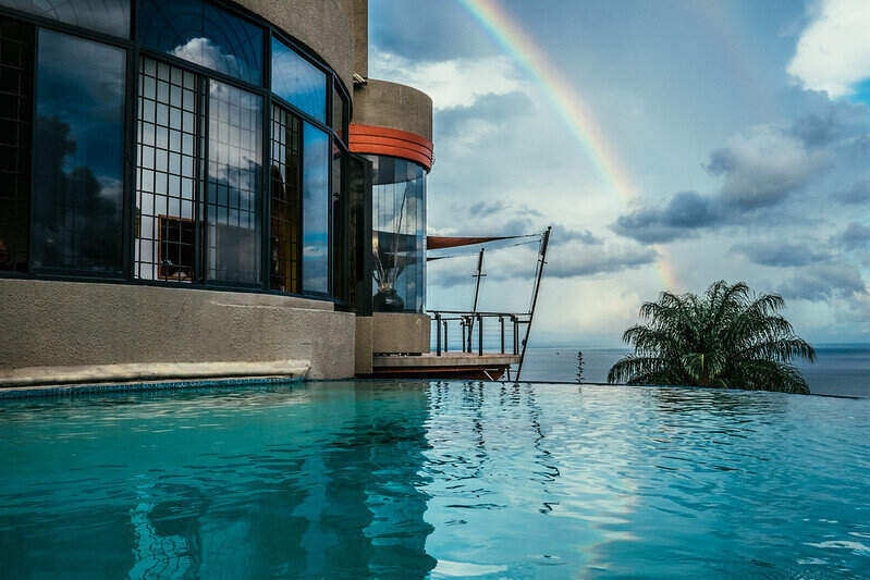 Rainbow seen in the distance looking across and infinity pool