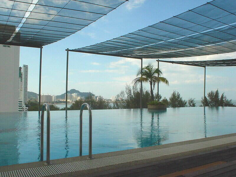 Infinity pool with sun-blocking screens hanging across the pool, above it