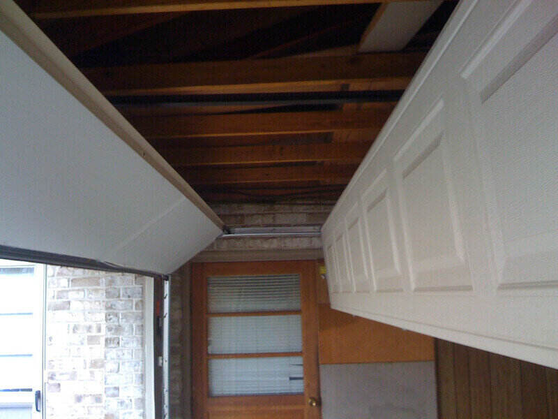 Broken garage door panels hanging from the ceiling