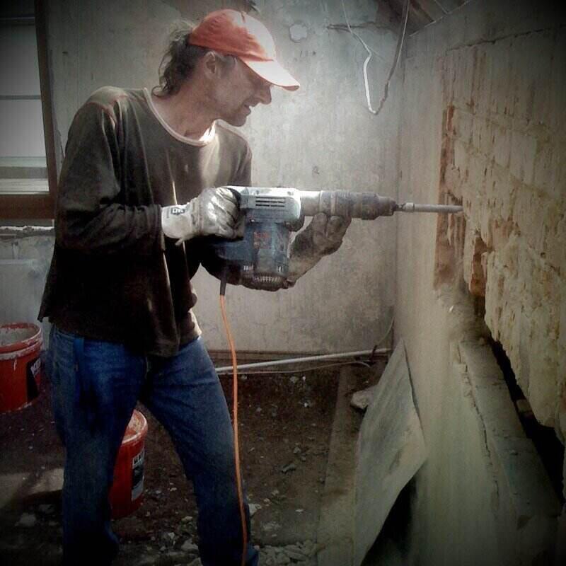 Msn using a hammer drill to break up a concrete wall