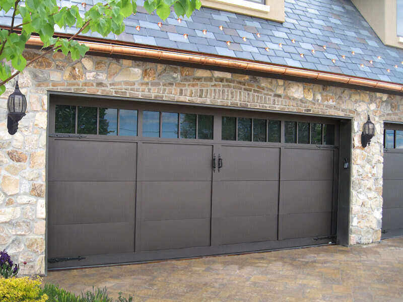 Garage door with a stone foundation and copper gutters
