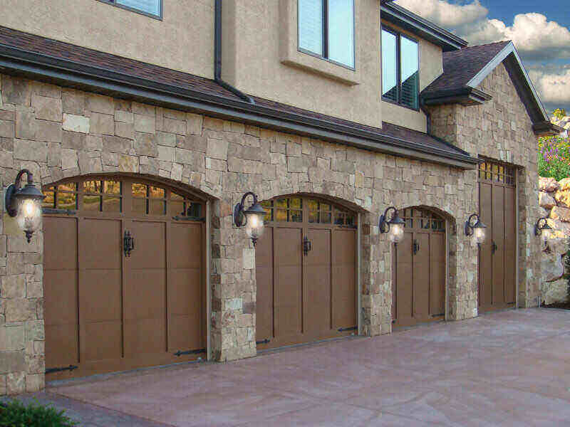 Large, stone, 3 car garage with wood doors