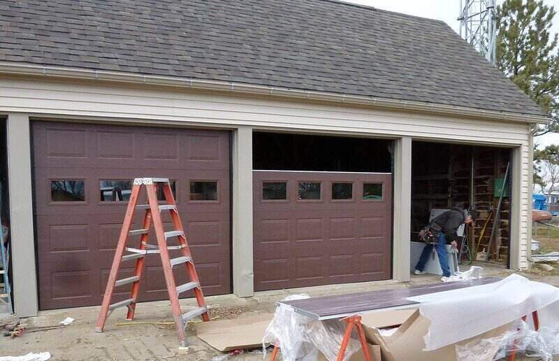 Person installing 3 garage doors