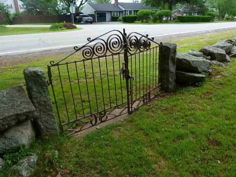 Old iron gate set between large stone columns