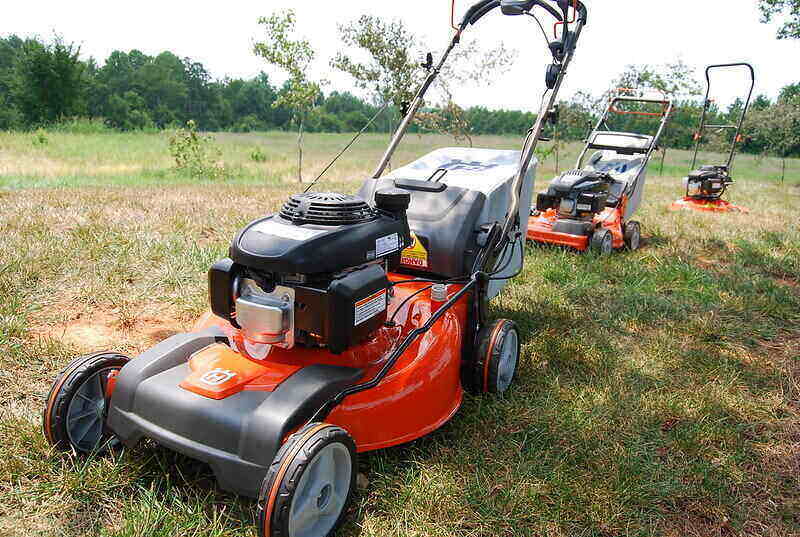 Three lawn mowers lined up in a row