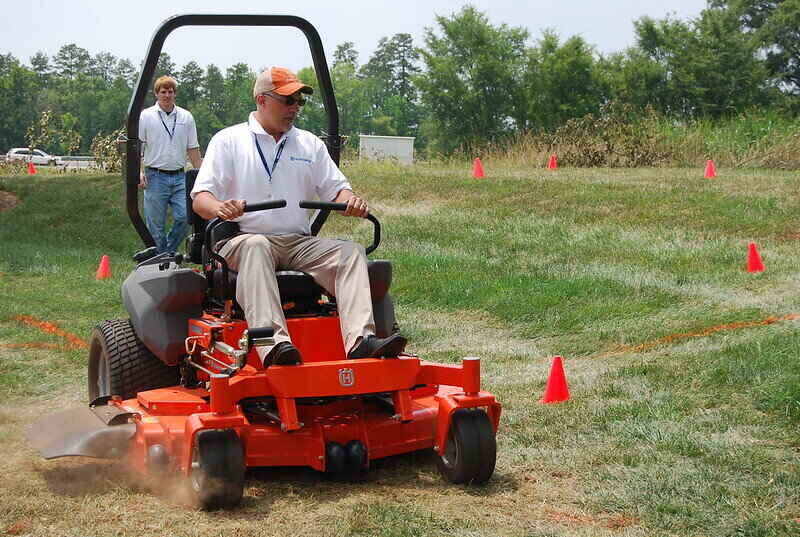 Man driving a red zero-turn mower