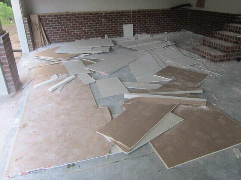 Drywall boards scattered across a garage floor