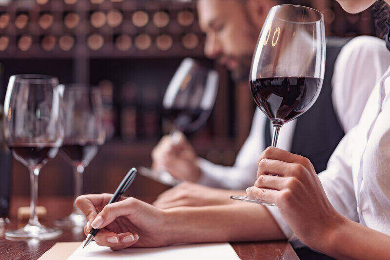 Man and woman tasting wine and taking notes