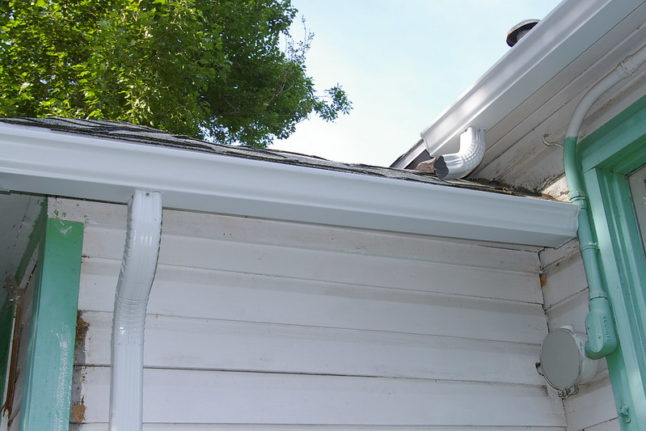 Closeup of white seamless gutters on house