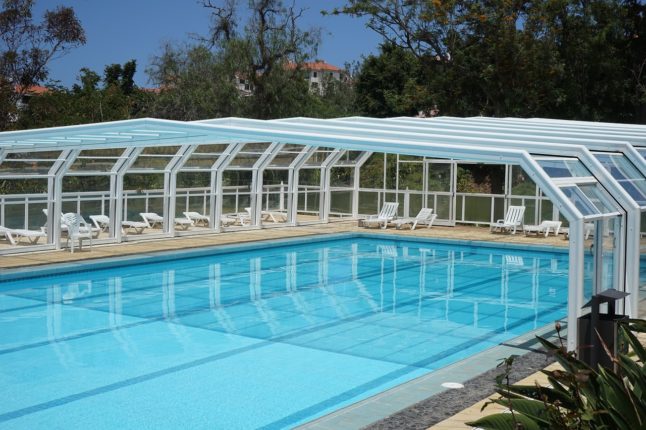 Swimming pool with glass enclosure