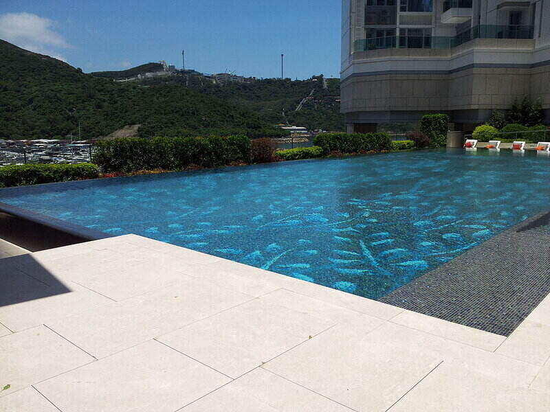 Outdoor pool with white tile for the outside walkway and patio sitting area