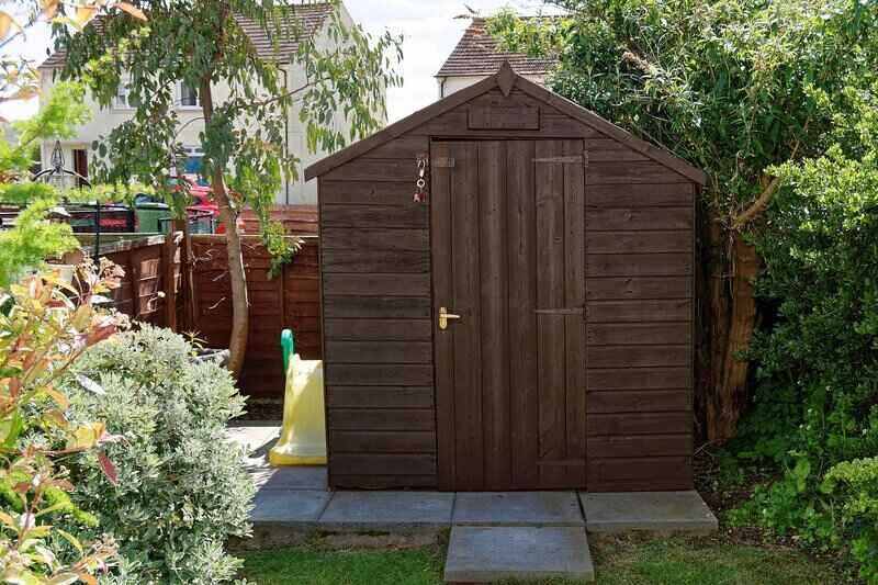 Wooden shed in a backyard, set on pavers