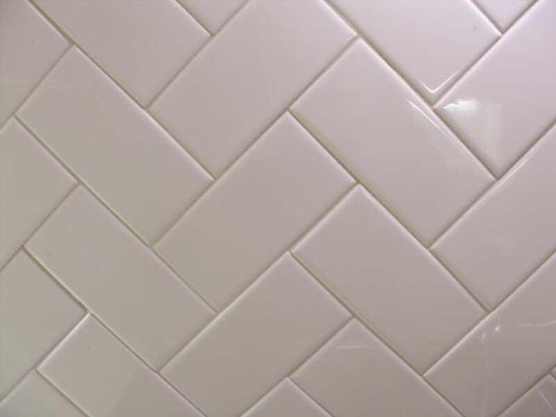Close-up of white tile set in herringbone style