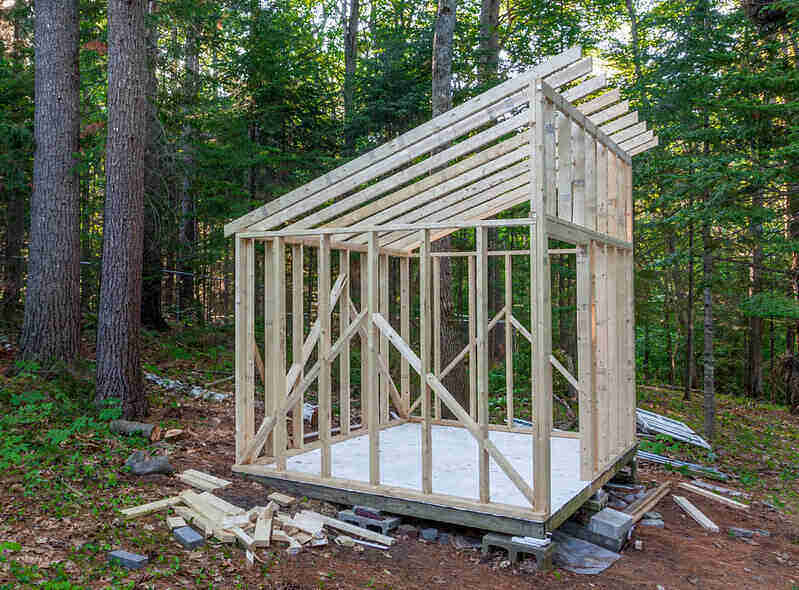 Wooden shed in the process of being built, with only the floor and the framing done