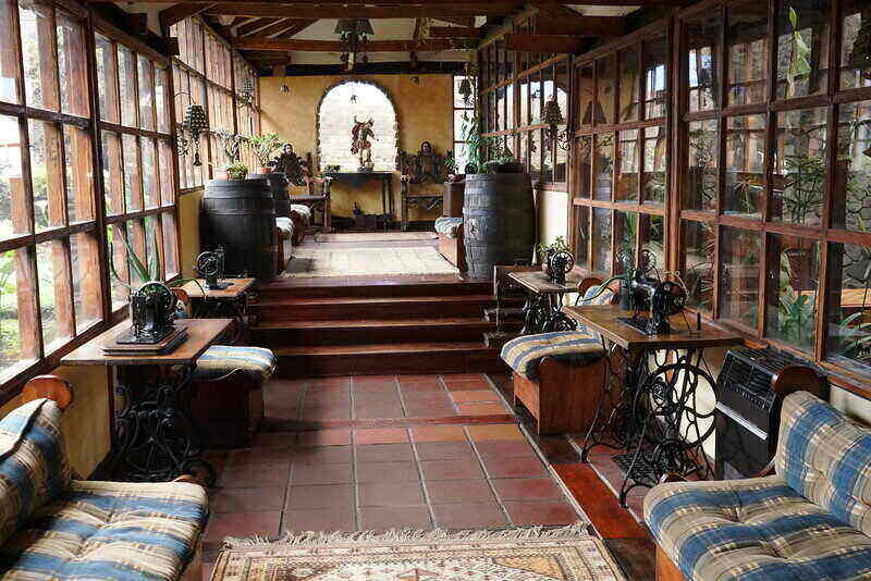 Beautifully decorated sunroom with windows either side of the sitting area.