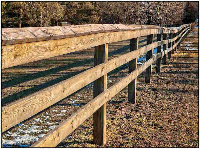 Wood split rail fence viewed going out into the distance