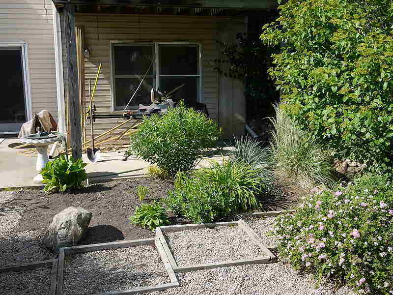 pea gravel set in wooden frames and around landscaping in a backyard