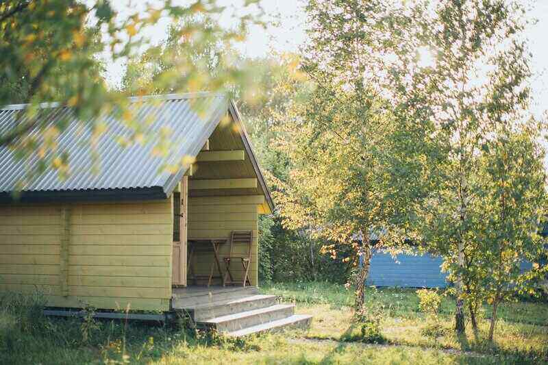 Shed surrounded by trees, with a patio and bistro seating